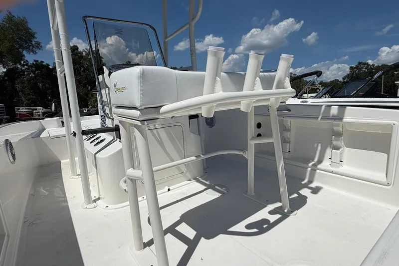 Slide: The Image of 2025 Bayliner Trophy T18 boat interior with rod holders and seating under a clear blue sky. - 21