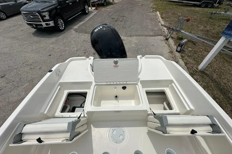 Slide: The Image of 2025 Bayliner Trophy T18 boat interior with storage compartments and seating, parked near a truck. - 27
