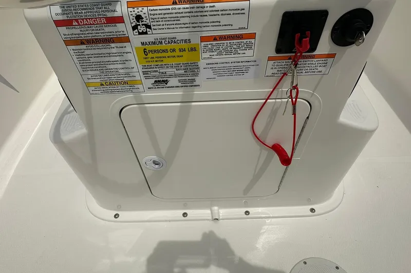 Slide: The Image of Bayliner Trophy T18 2025 boat safety warnings and capacity labels on white panel. - 13