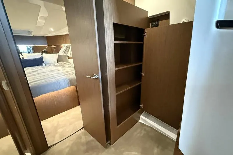 Slide: The Image of Interior of 2026 Beneteau Antares 11 Coupe showing bedroom and wooden storage cabinet. - 22