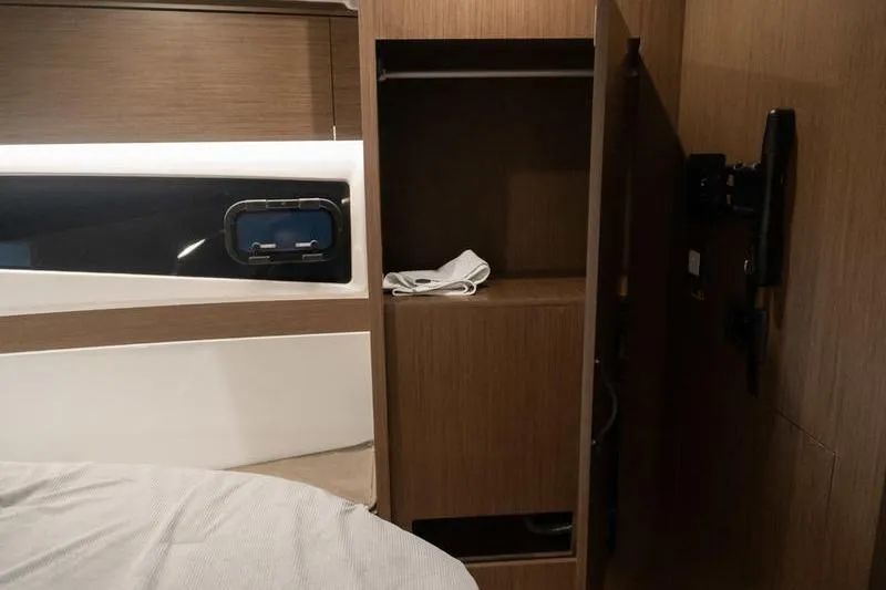 Slide: The Image of Interior of 2026 Beneteau Antares 11 Coupe, featuring wooden cabinetry and a small window. - 26