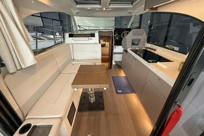 Slide: The Image of Interior of 2026 Beneteau Antares 11 Coupe, featuring modern seating and kitchen area. - 9