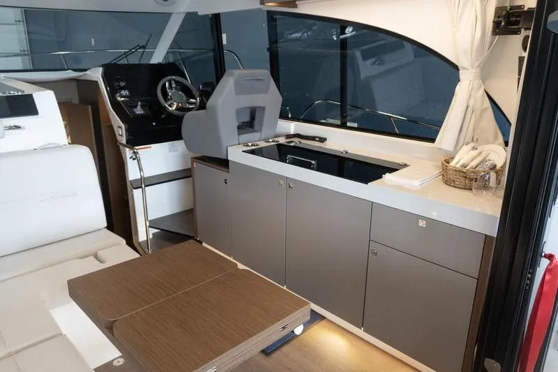 Slide: The Image of Interior of 2026 Beneteau Antares 11 Coupe with modern kitchen and helm station. - 11