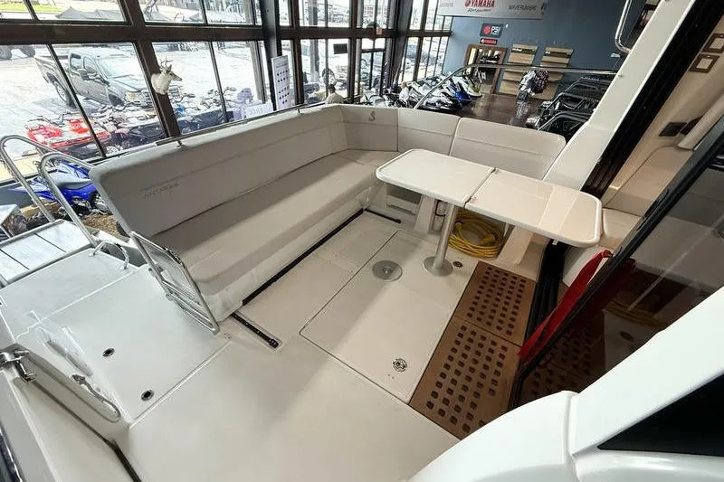 Slide: The Image of 2026 Beneteau Antares 11 Coupe interior with seating and table in showroom. - 8