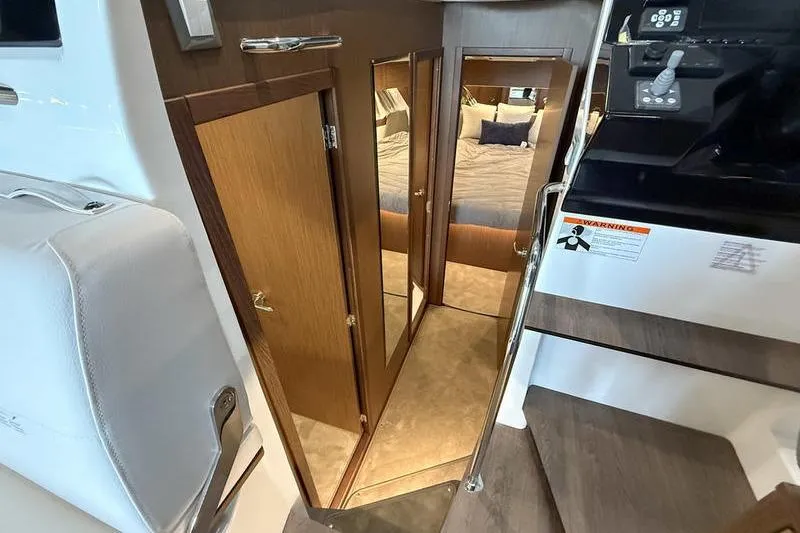 Slide: The Image of Interior view of 2026 Beneteau Antares 11 Coupe, featuring a cozy cabin and wooden finishes. - 21