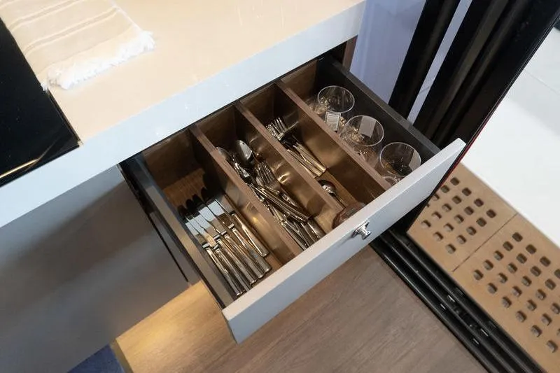 Slide: The Image of Drawer with organized cutlery and glasses in a 2026 Beneteau Antares 11 Coupe yacht kitchen. - 15