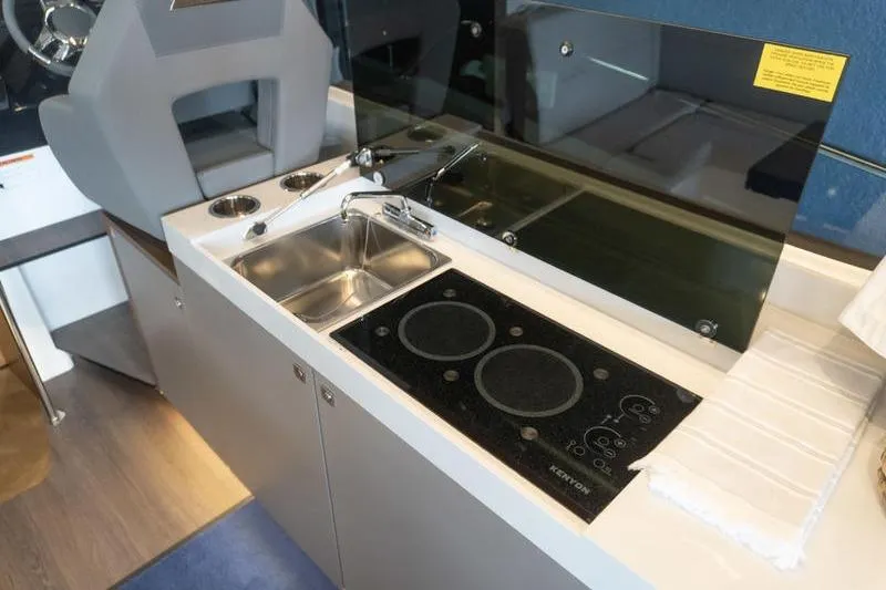 Slide: The Image of Compact kitchen area in 2026 Beneteau Antares 11 Coupe with stove and sink. - 12