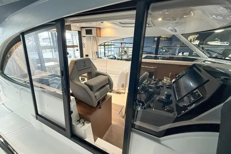 Slide: The Image of Interior view of 2026 Beneteau Antares 11 Coupe, showcasing helm and seating area. - 32