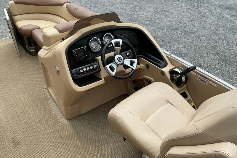 Slide: The Image of 2019 Avalon Catalina Quad Lounge boat interior with beige seating and modern dashboard controls. - 7