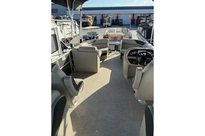 Slide: The Image of 2023 South Bay 224RS LE pontoon boat interior with beige seating and steering console. - 7