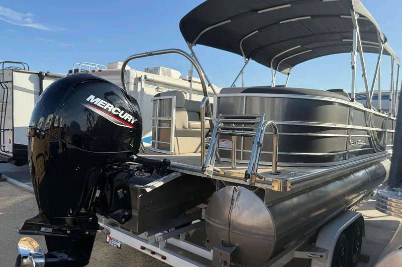 Slide: The Image of 2023 South Bay 224RS LE pontoon boat with Mercury outboard motor, parked on a trailer. - 3