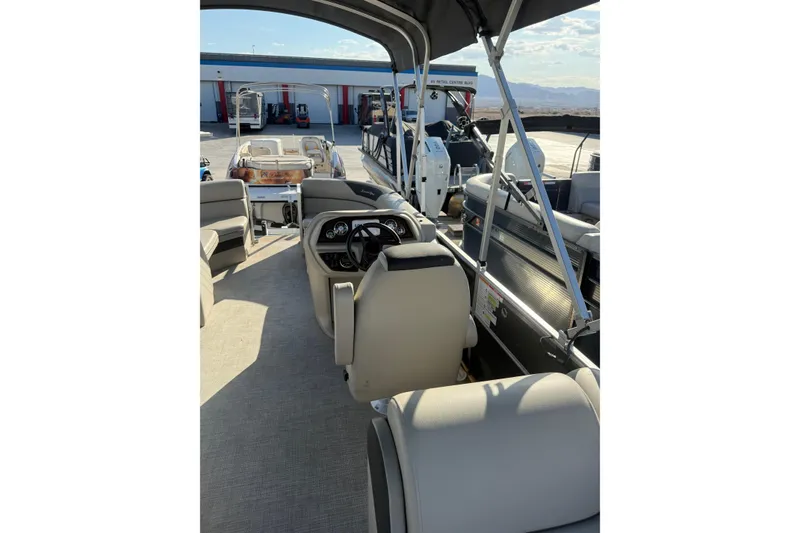 Slide: The Image of 2023 South Bay 224RS LE pontoon boat interior with helm and seating. - 11