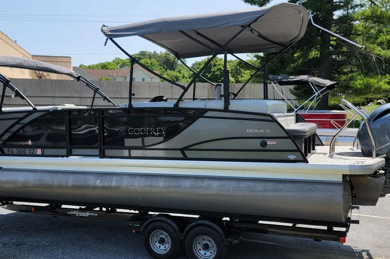 Slide: The Image of 2021 Godfrey Monaco 235 C pontoon boat on trailer, featuring canopy and sleek design. - 5