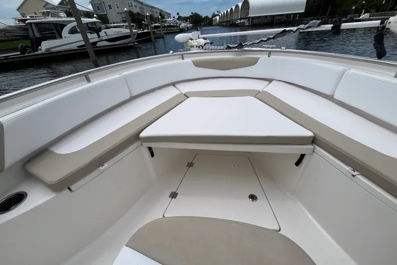 Slide: The Image of 2019 Robalo R242 Center Console boat interior with cushioned seating and storage compartment. - 26