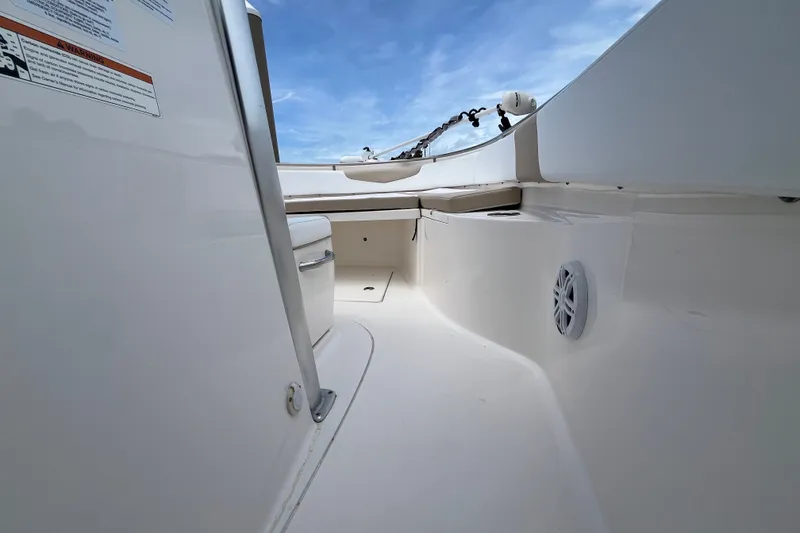 Slide: The Image of 2019 Robalo R242 Center Console boat interior with seating and speaker, under blue sky. - 14