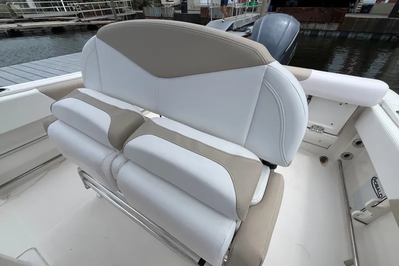 Slide: The Image of 2019 Robalo R242 Center Console boat seating, featuring white and beige cushioned seats. - 23