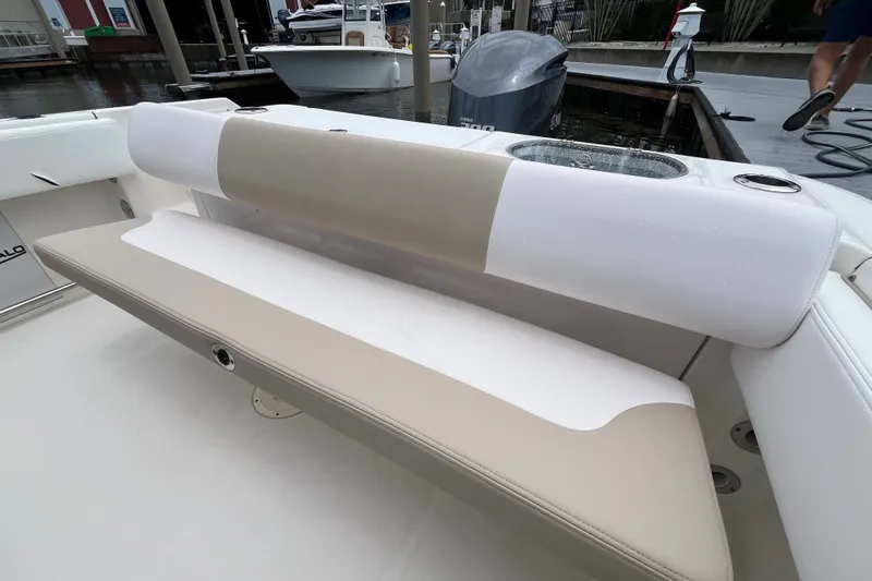 Slide: The Image of 2019 Robalo R242 Center Console boat with beige and white seating at a dock. - 18