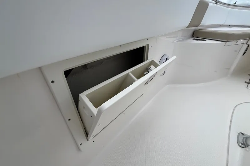 Slide: The Image of 2019 Robalo R242 Center Console boat storage compartment with open hatch and seating area. - 21