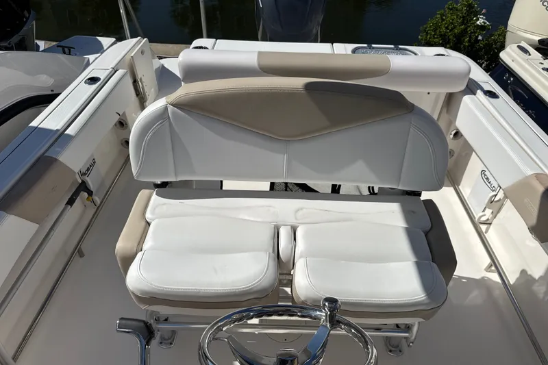 Slide: The Image of 2019 Robalo R242 Center Console boat interior with cushioned seating and steering wheel. - 14