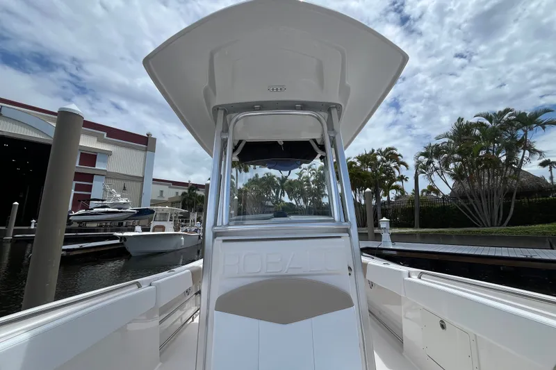 Slide: The Image of 2019 Robalo R242 Center Console boat docked at marina under cloudy sky. - 13