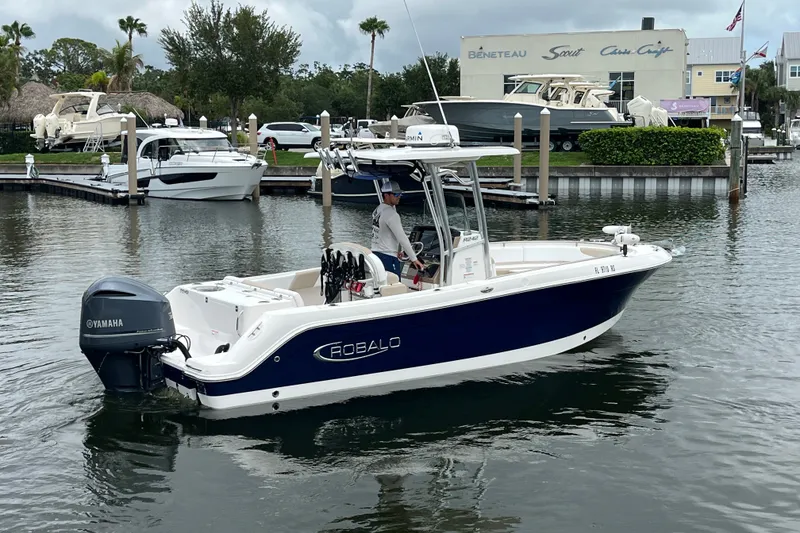 Slide: The Image of 2019 Robalo R242 Center Console boat with Yamaha engine in marina setting. - 3