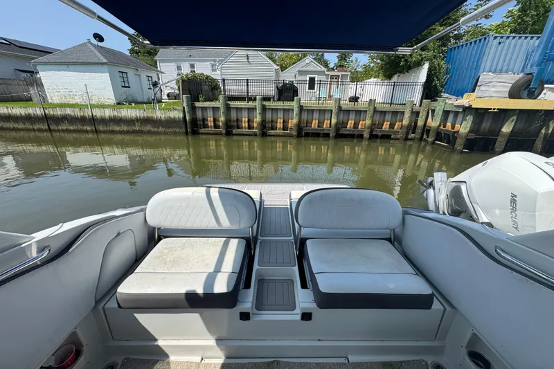 Slide: The Image of 2018 Crownline Eclipse E30 boat interior with seating, docked by a waterfront. - 6