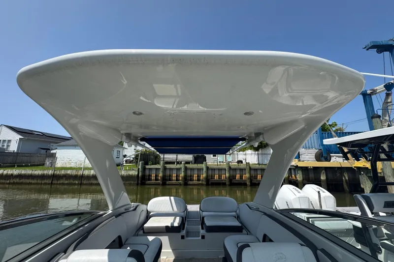 Slide: The Image of 2018 Crownline Eclipse E30 boat interior with sleek design and spacious seating under a clear blue sky. - 10