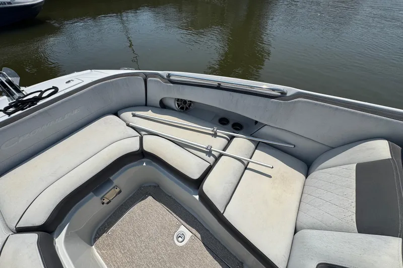 Slide: The Image of 2018 Crownline Eclipse E30 boat interior with cushioned seating and metal rods, docked on water. - 19