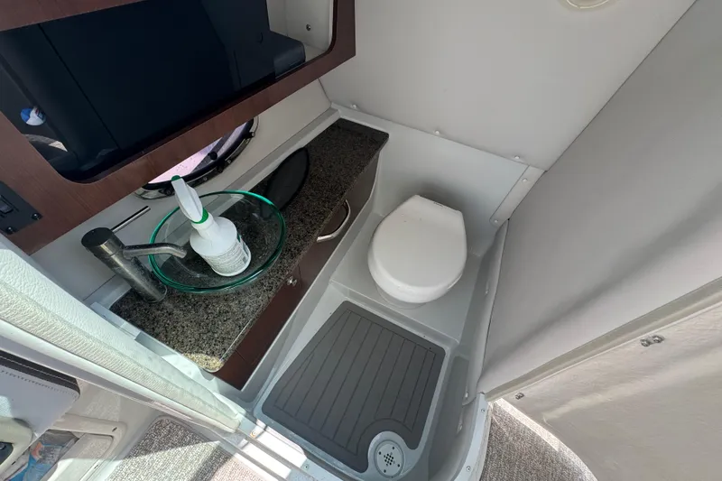 Slide: The Image of 2018 Crownline Eclipse E30 boat bathroom with sink, toilet, and countertop. - 16