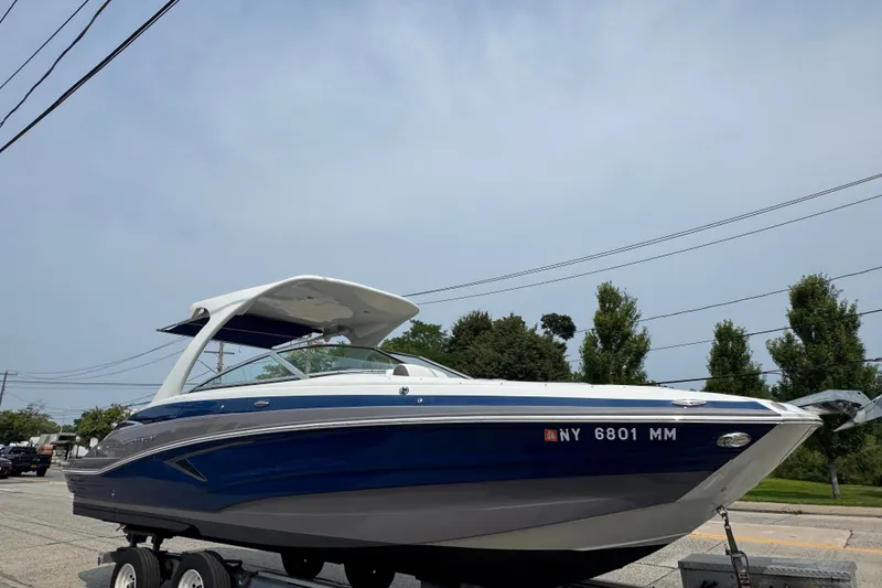 The Image of 2018 Crownline Eclipse E30 boat on trailer, parked on street under clear sky. - 0