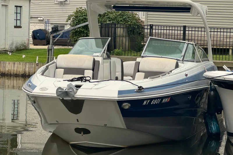 The Image of 2018 Crownline Eclipse E30 boat docked in a residential canal setting. - 1