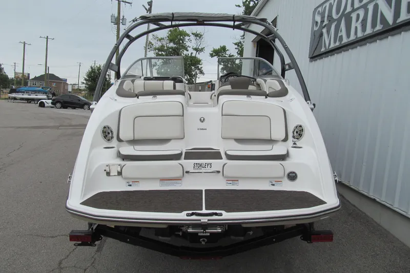 Slide: The Image of 2013 Yamaha Boats 242 Limited S, rear view at marina, showcasing seating and design. - 3