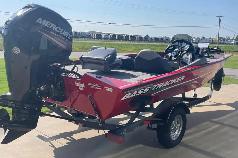 Slide: The Image of 2015 Tracker Pro Team 175 TXW bass boat with Mercury engine, parked on a trailer. - 4