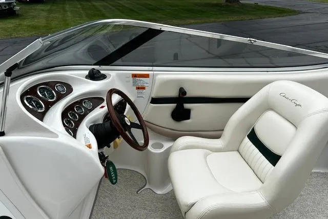 Slide: The Image of 1999 Chris-Craft 200 Bowrider SS interior with white seating and classic dashboard design. - 11