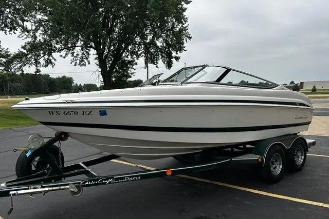 Slide: The Image of 1999 Chris-Craft 200 Bowrider SS on trailer, parked outdoors, overcast sky. - 5