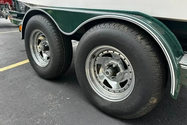 Slide: The Image of Trailer wheels of a 1999 Chris-Craft 200 Bowrider SS boat on pavement. - 35
