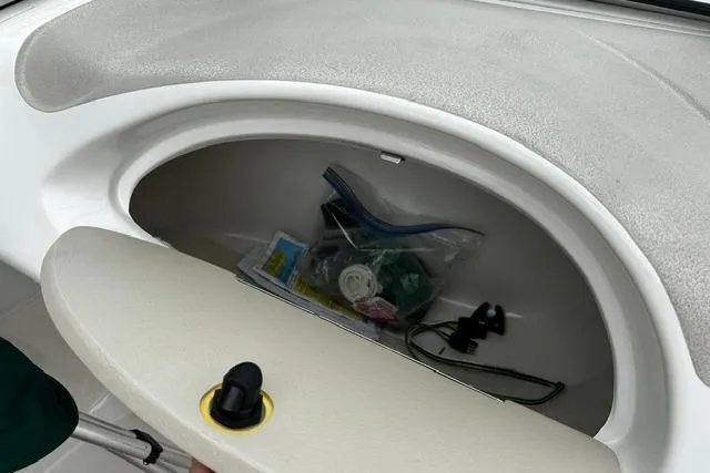 Slide: The Image of Storage compartment in a 1999 Chris-Craft 200 Bowrider SS boat, containing various items. - 19