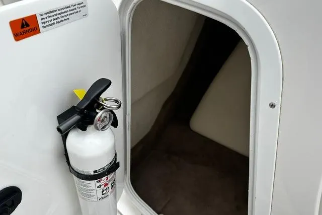 Slide: The Image of 1999 Chris-Craft 200 Bowrider SS interior with fire extinguisher and storage compartment. - 20