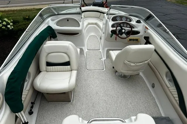 Slide: The Image of 1999 Chris-Craft 200 Bowrider SS interior with white seating and steering console. - 9