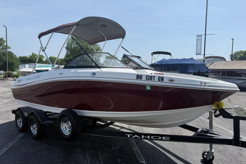 Slide: The Image of 2020 Tahoe 500 TS boat on trailer, maroon and white, parked outdoors. - 3