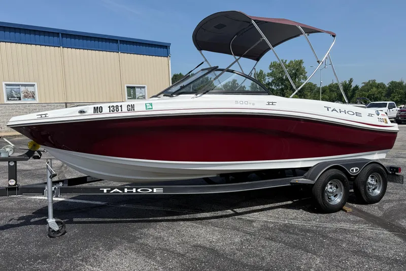 The Image of 2020 Tahoe 500 TS boat on trailer, red and white, parked outdoors. - 1