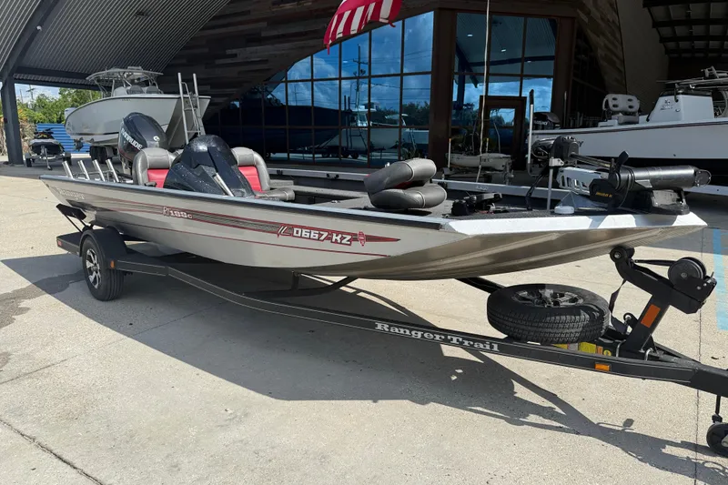 Slide: The Image of 2018 Ranger RT188C fishing boat on trailer, parked outside a modern building. - 2