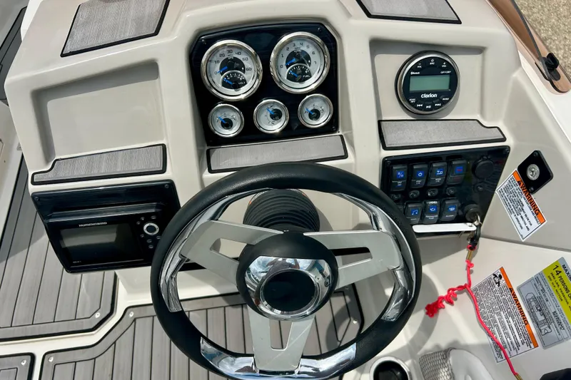 Slide: The Image of 2023 Starcraft SVX 211 IO boat dashboard with steering wheel and control gauges. - 13