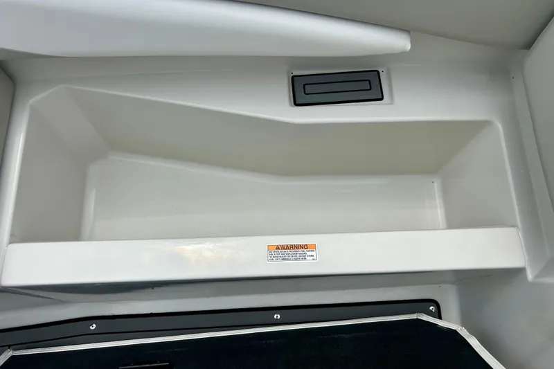 Slide: The Image of 2023 Starcraft SVX 211 IO boat storage compartment with warning label. - 49