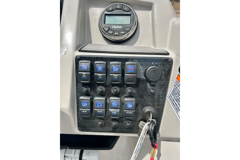 Slide: The Image of Control panel of 2023 Starcraft SVX 211 IO boat with Clarion audio system and switches. - 11