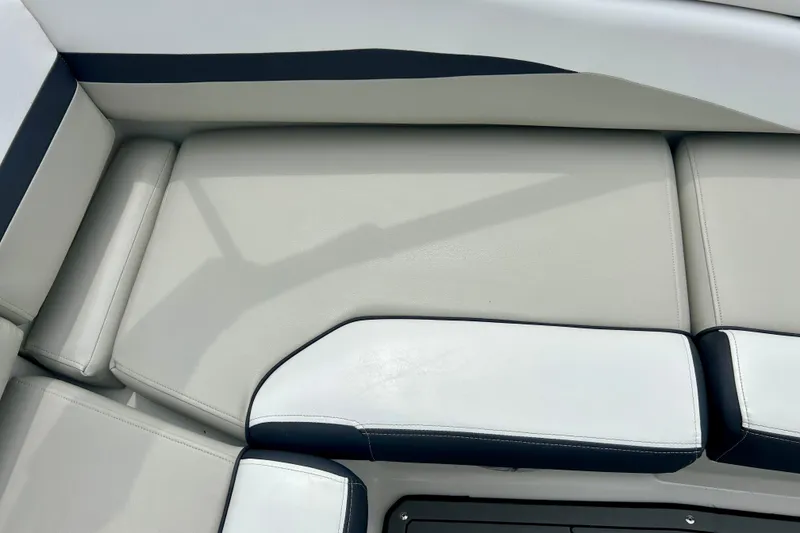 Slide: The Image of 2023 Starcraft SVX 211 IO boat interior with sleek, cushioned seating in white and black. - 24