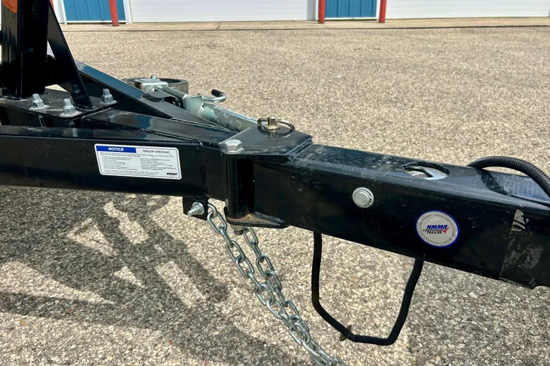 Slide: The Image of Trailer hitch of 2023 Starcraft SVX 211 IO boat, featuring safety chains and labels. - 21