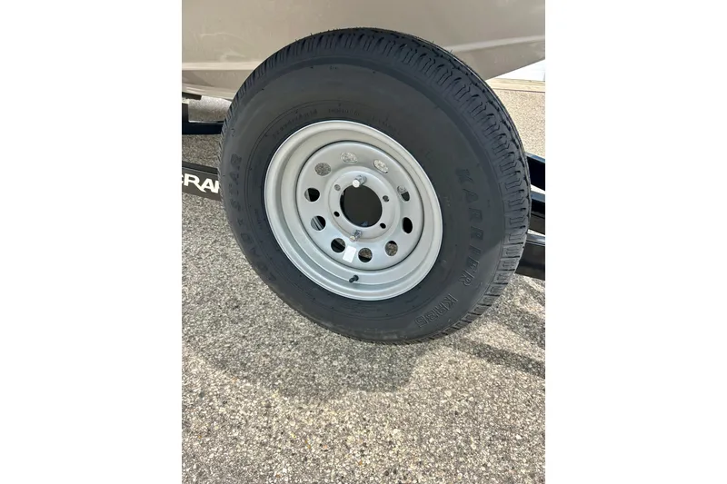 Slide: The Image of 2023 Starcraft SVX 211 IO trailer tire on pavement, showcasing durable wheel design. - 37