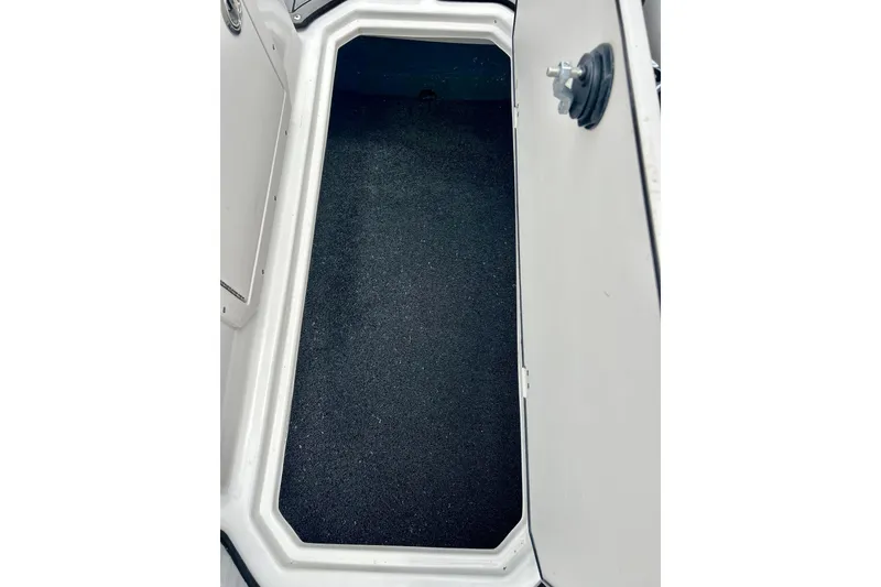 Slide: The Image of 2023 Starcraft SVX 211 IO boat storage compartment with black interior lining. - 53