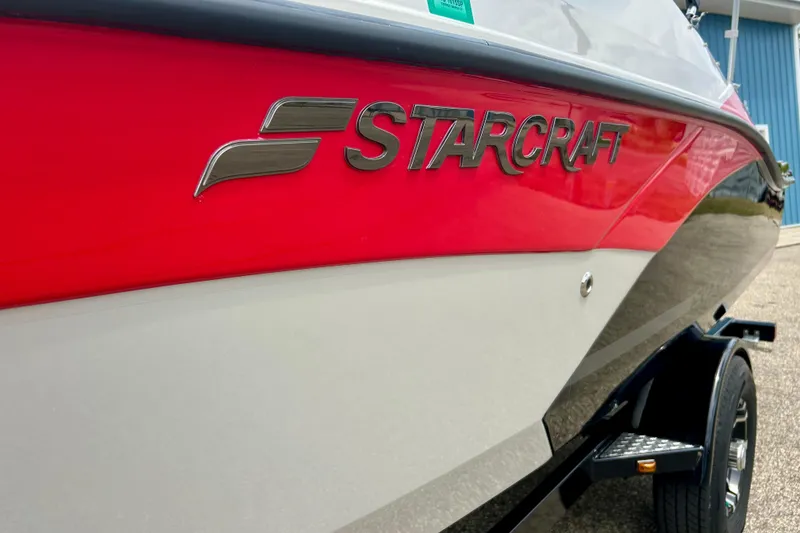 Slide: The Image of 2023 Starcraft SVX 211 IO boat with red and white exterior on trailer. - 5